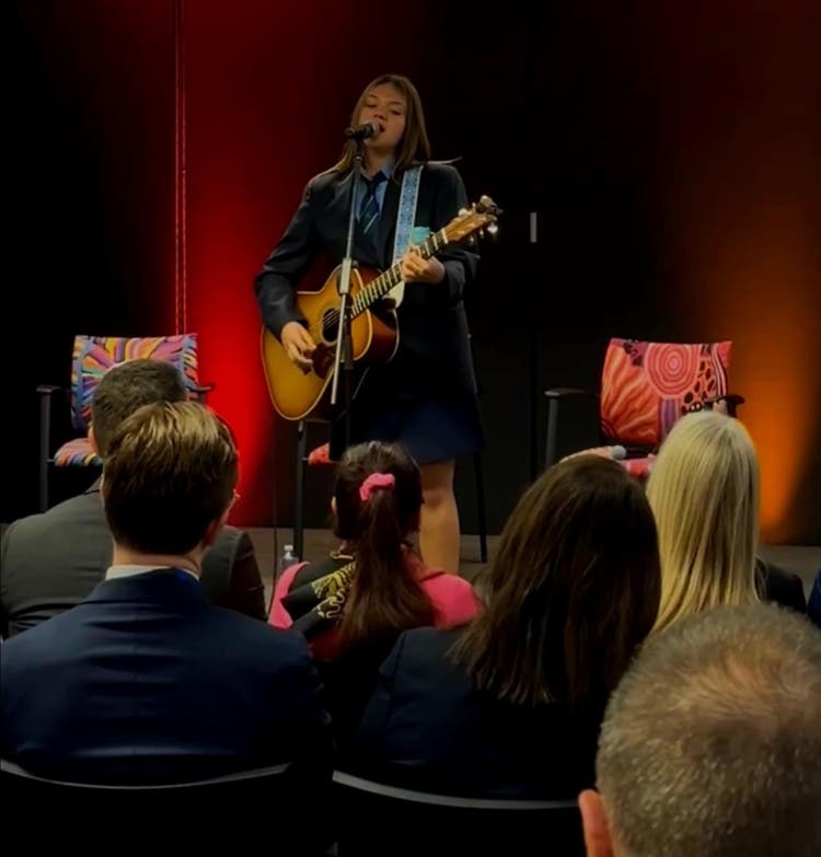 Kyla Roberts performing on stage with guitar